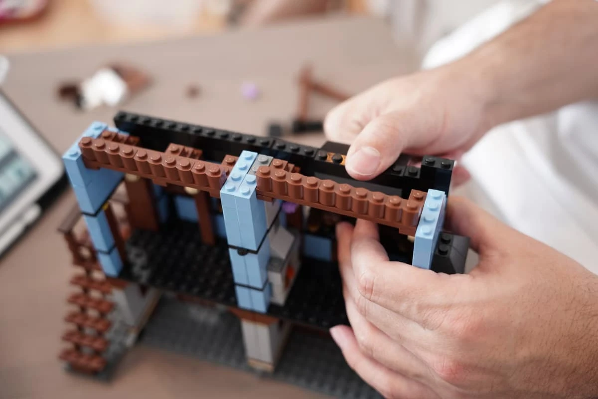 Žmonės dėlioja LEGO® rinkinį